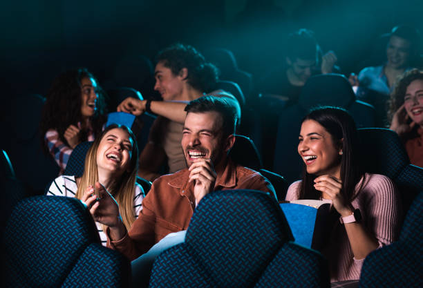 grupo de personas alegres riendo mientras ven películas en el cine. - cine fotografías e imágenes de stock