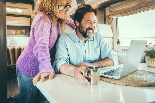 istock Modern travel couple enjoy connection technology using laptop inside a camper van home. Alternative office and house people lifestyle. Digital nomad smart working man and woman trip 1365387778