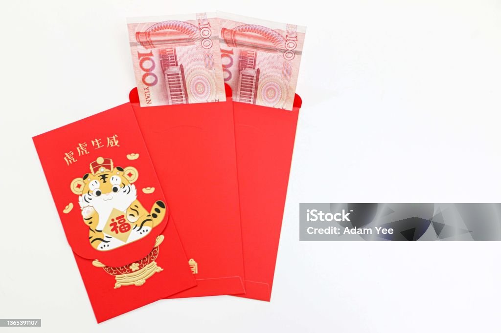Chinese New Year lucky red envelopes for tiger year with 100 Chinese Yuan notes inside, Chinese greeting text translates as blessing with vigour and vitality of a tiger Abundance Stock Photo