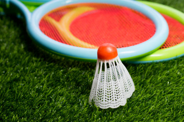 istock Red shuttlecock and badminton rackets on the grass 1365393939