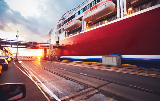 cars are waiting in a queue for loading onboard of big ferry ship, cruise liner in transport port