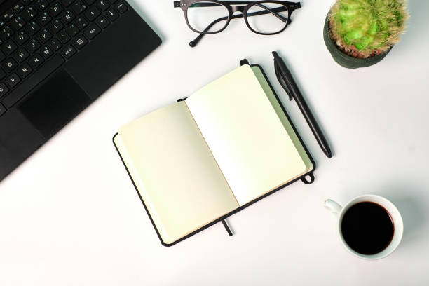 istock Top view of a notebook, laptop, glasses and coffee cup on a white background. Copy space, business concept 1365394736