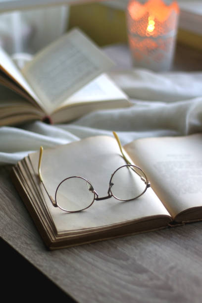 istock Open Books, Reading Glasses and Lit Candle 1365397019