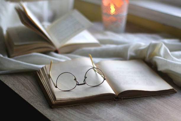 istock Open Books, Reading Glasses and Lit Candle 1365397595