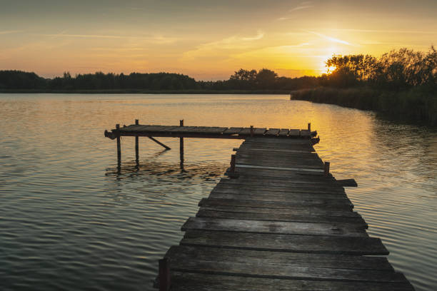 istock Sunset over a quiet lake with a pier 1365400852