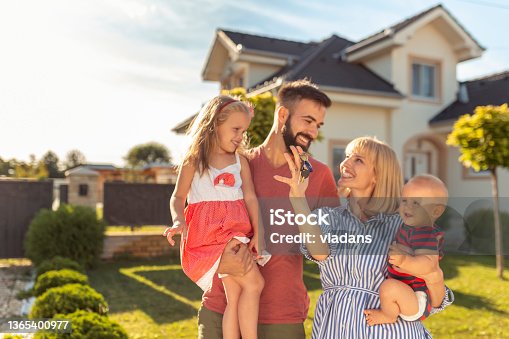 istock Family holding keys after buying a new house 1365400977