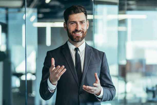 istock Businessman looking at camera and talking on video call, having fun gesturing with hands, webcam view 1365401206
