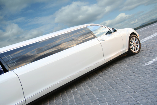 White limousine on a cobblestone.
