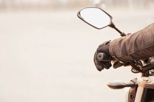 la mano del motociclista descansa sobre el volante de la motocicleta. vista de primer plano - motociclista fotografías e imágenes de stock