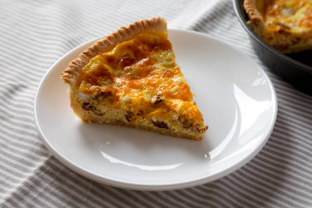 istock Homemade Bacon Quiche with Eggs and Cheddar Cheese on a white plate, side view. 1365402252