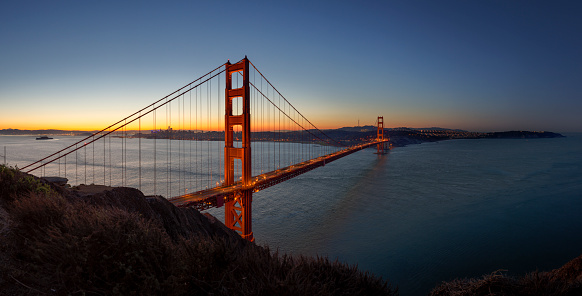 Golden Gate Bridge Sunrise Panorama. Beautiful iconic Golden Gate Bridge at early morning sunrise twilight. Long Time Exposure, Panorama Shot. Golden Gate Bridge, San Francisco, California, USA, North America.