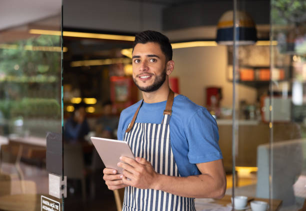 istock Waiter working at a restaurant waiting for clients at the door 1365404988