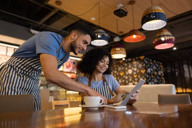 istock Team of waiters working at a restaurant and looking at the menu on a tablet 1365405010