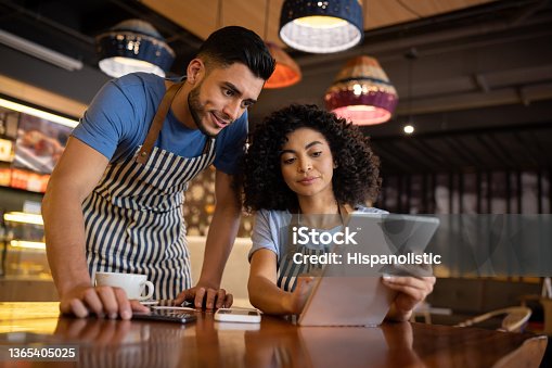 istock Team of waiters working at a restaurant and looking at the menu on a tablet 1365405025