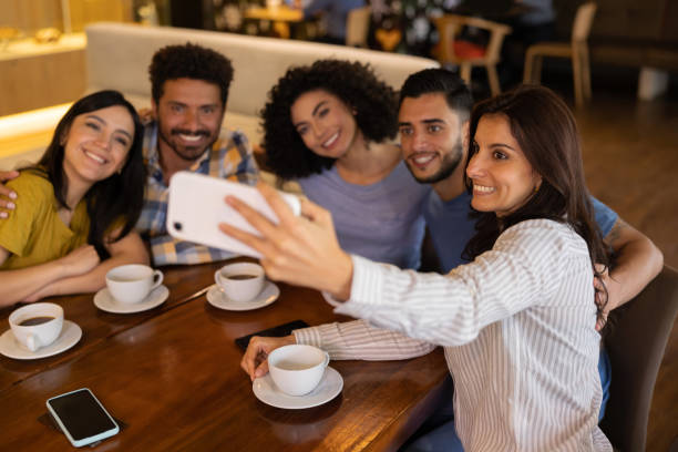 istock Happy group of friends taking a selfie at a restaurant 1365405030