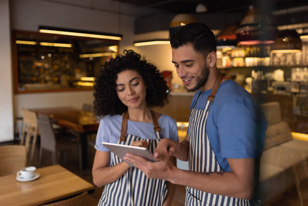 istock Waiters working at a restaurant and looking at the menu on a tablet computer 1365405033