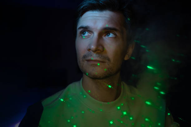 istock Creative idea, concept. young man and a projection of colored patterns on smoke. 1365407622