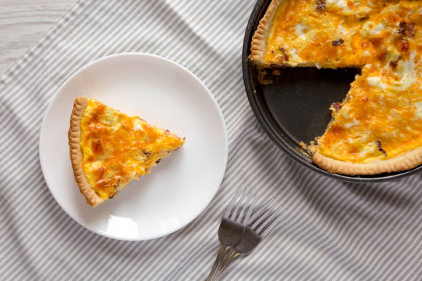 istock Homemade Bacon Quiche with Eggs and Cheddar Cheese on cloth, view from above. Flat lay, overhead, top view. 1365409421