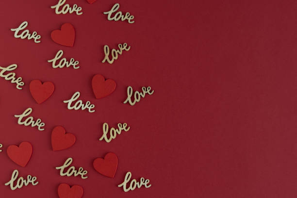 istock Red cardboard background with word LOVE in wood. Copy space. 1365409473