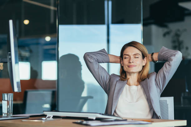 istock business owner woman resting during working hours puts her hands behind her head, thinks about business plans, works in a modern office 1365410480