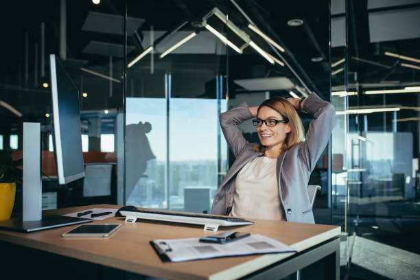 istock business owner woman resting during working hours puts her hands behind her head, thinks about business plans, works in a modern office 1365410486