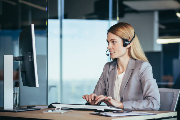 female employee call center, video link and tech support, employee uses headset and webcam - hotel reception customer service representative headset receptionist imagens e fotografias de stock