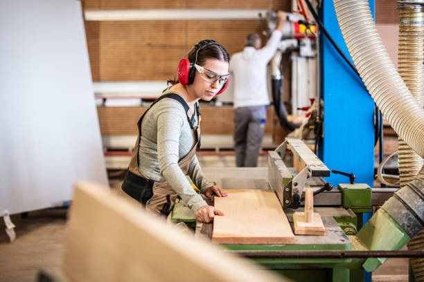 carpintero y carpintera en el trabajo, hombre y mujer están elaborando con madera en un taller - carpintero fotografías e imágenes de stock