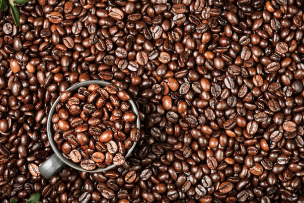 Coffee background with space for text, layout of coffee beans on the table and black cup for espresso coffee, coffee advertising idea stock photo