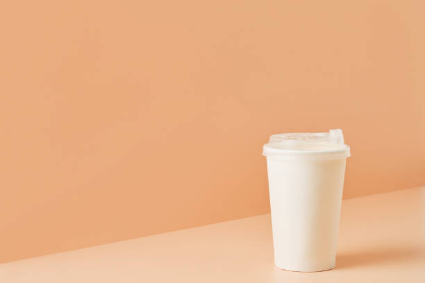 istock Paper unbranded white glass for drinks on a colored background, close-up with copy space for text.Cardboard eco-friendly cup 1365410848