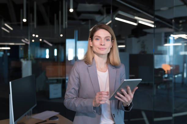 istock Business woman successfully uses a tablet computer in a modern office, a confident manager and focused on work 1365410908