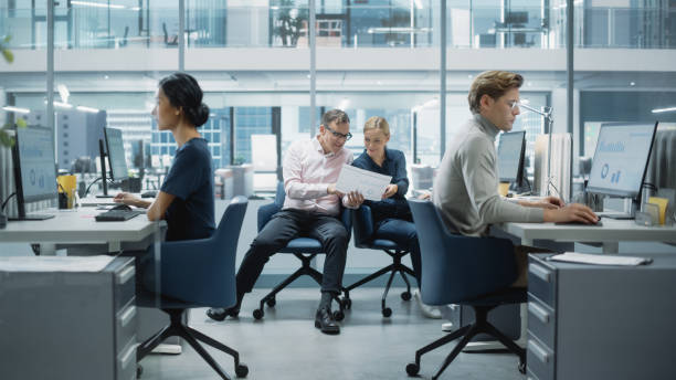 istock Diverse Team of Managers Working and Having Discussions in Modern Big City Office. Colleagues Work on New Business Opportunities, Evaluate Financial Reports, Plan Investment Strategy. 1365412399