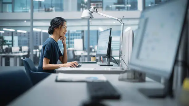 Photo of In Big Diverse Corporate Office: Portrait of Beautiful Asian Manager Using Desktop Computer, Businesswoman Managing Company Operations, Analysing Statistics, Commerce Data, Marketing Plans.