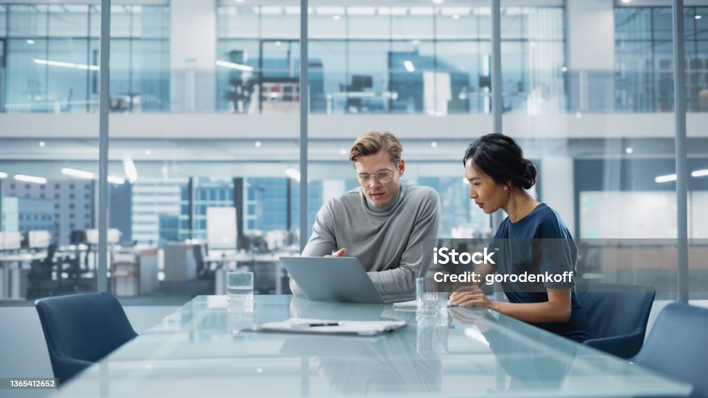 Multiethnic Diverse Office Conference Room Meeting: Team of Two Creative Entrepreneurs Talk, Discuss Growth Strategy. Stylish Young Businesspeople work on Investment and Marketing Projects. Business Stock Photo