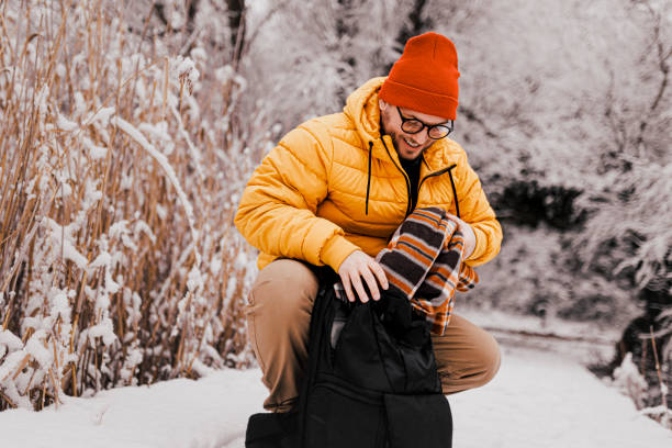istock Young man packing backpack for snowy day 1365412863