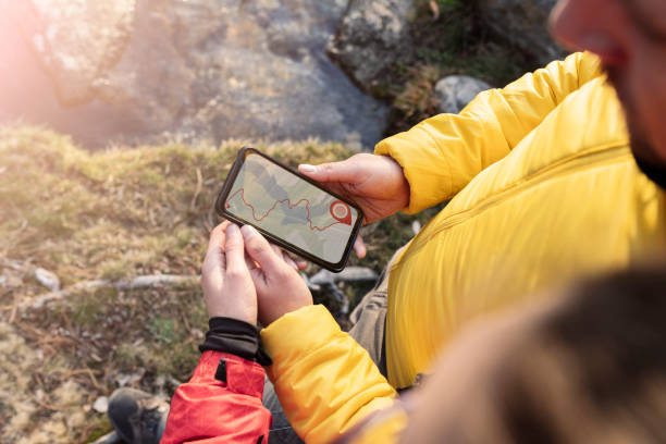 istock people using gps navigator app, forest hiking, couple on mountain at sunset 1365413283