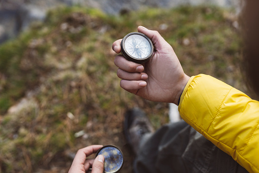 traveler's hand holding a compass