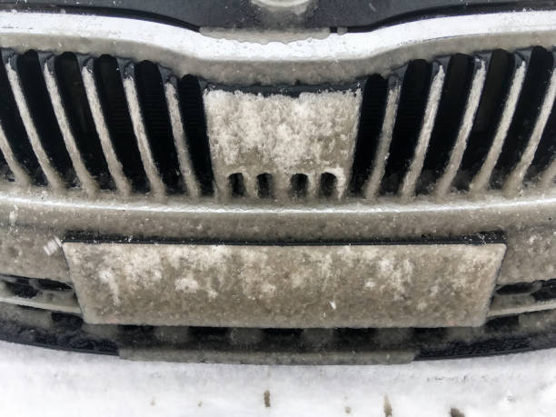 The detail of the car radiator grille fully covered by slush. The radar sensor is blind. Problem for modern systems caused by weather.