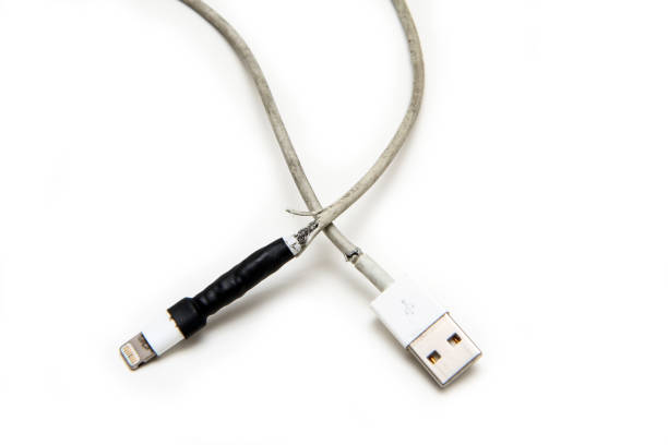 smart phones charger with broken and frayed cable The detail of smart phones charger with broken and frayed cable. Already once fixed by tape, but broken again. Typical problem of the users. phone charger cable stock pictures, royalty-free photos & images