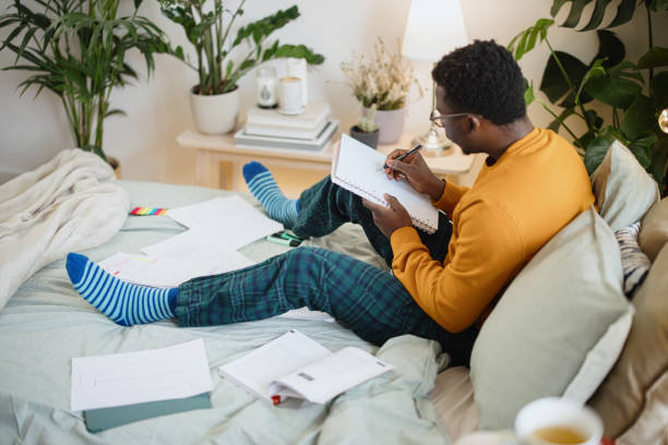 istock Male student taking practice test and studying at home 1365414826