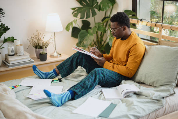 istock Male student taking practice test and studying at home 1365414836