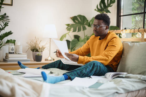 istock Male student taking practice test and studying at home 1365414866