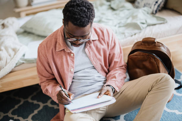 istock Young student taking notes from laptop and books for his exams 1365415163