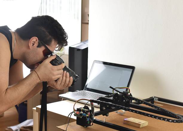 istock man photographs a laser engraving machine 1365416244