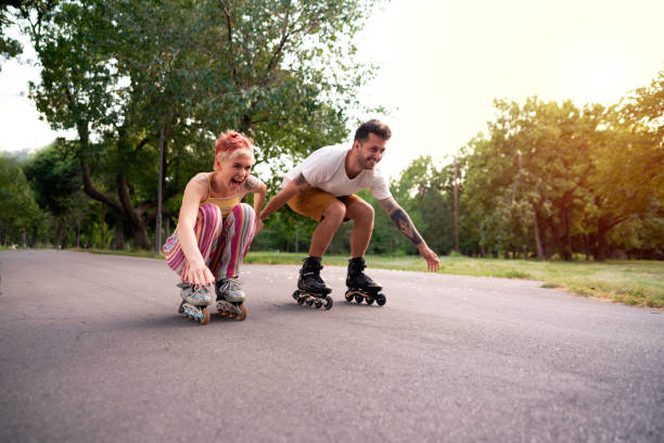 행복한 여자와 남자 데 재미 에 롤러 스케이트 - 인라인 스케이트 뉴스 사진 이미지