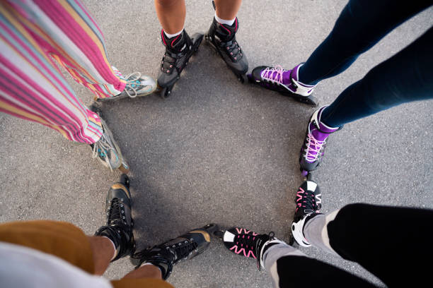 High-angle view of an unrecognizable group of people making star shape with their roller skates in a park .