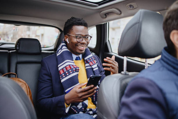 un hombre hace una llamada de negocios mientras toma un taxi - seat belt audio fotografías e imágenes de stock