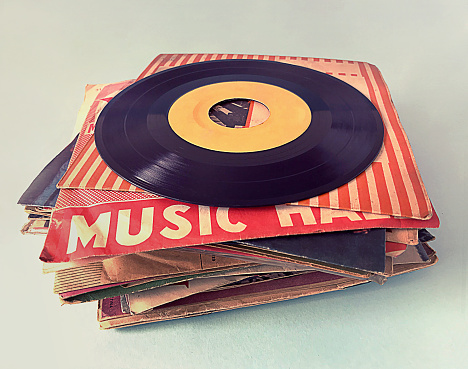 still life photography :  blank label phonograph disc with old headphone and old trophy on old wood shelf against art dark background