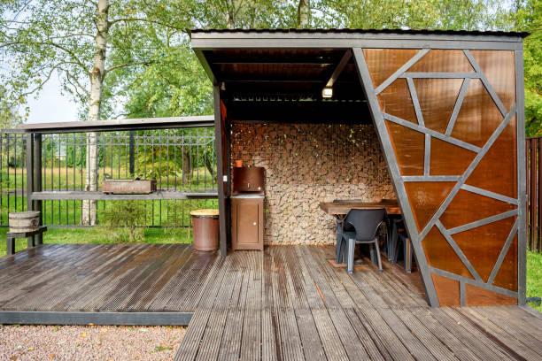 istock Picnic area with barbecue grill and table and chairs 1365419912