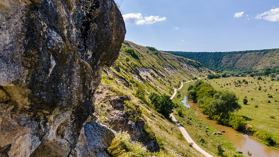 Aerial drone view of a valley with floating river, rock on the foreground, hill slopes and greenery in Moldova Aerial drone view of a valley with floating river, rock on the foreground, hill slopes and greenery in Moldova