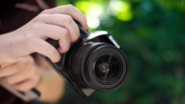 istock Woman holding a professional camera 1365421186